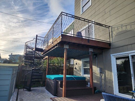 There is a hot tub on the deck of a house.