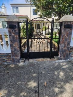 A wrought iron gate is in front of a house.