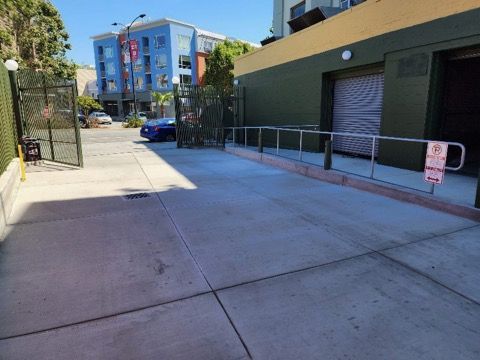 A parking lot with a handicapped ramp leading to a garage.