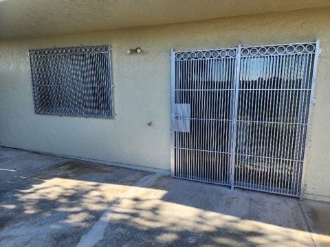 A white house with a fence and two windows.