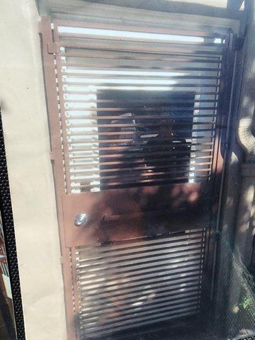 A person is standing in front of a metal gate.