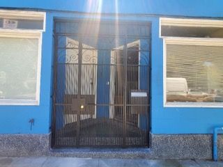 A blue building with a black gate in front of it.