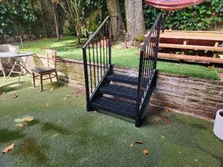 A set of stairs leading up to a patio with a table and chairs.