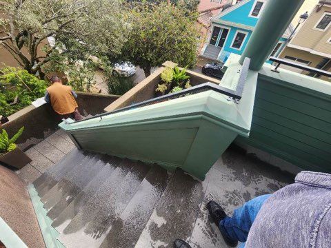 A man is sitting on the side of a set of stairs.