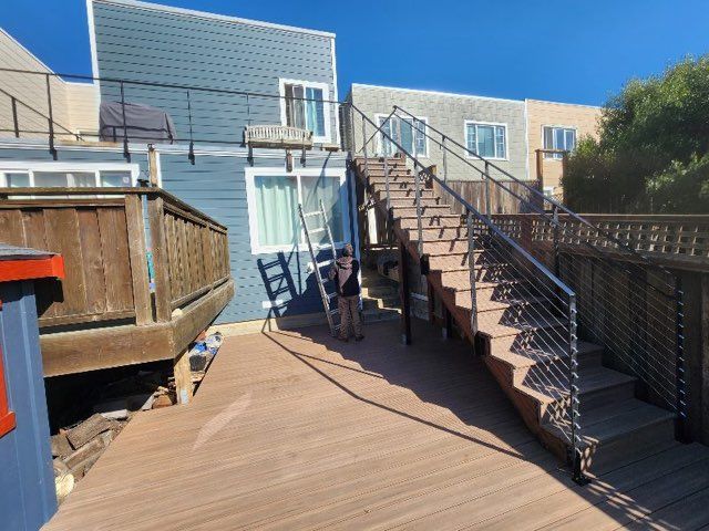 A wooden deck with stairs leading up to a house