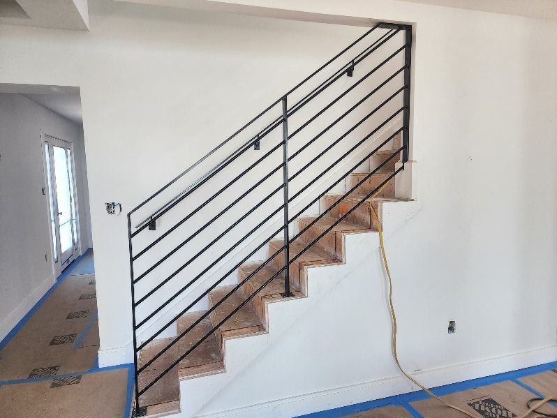 A staircase with a black railing is being built in a house.