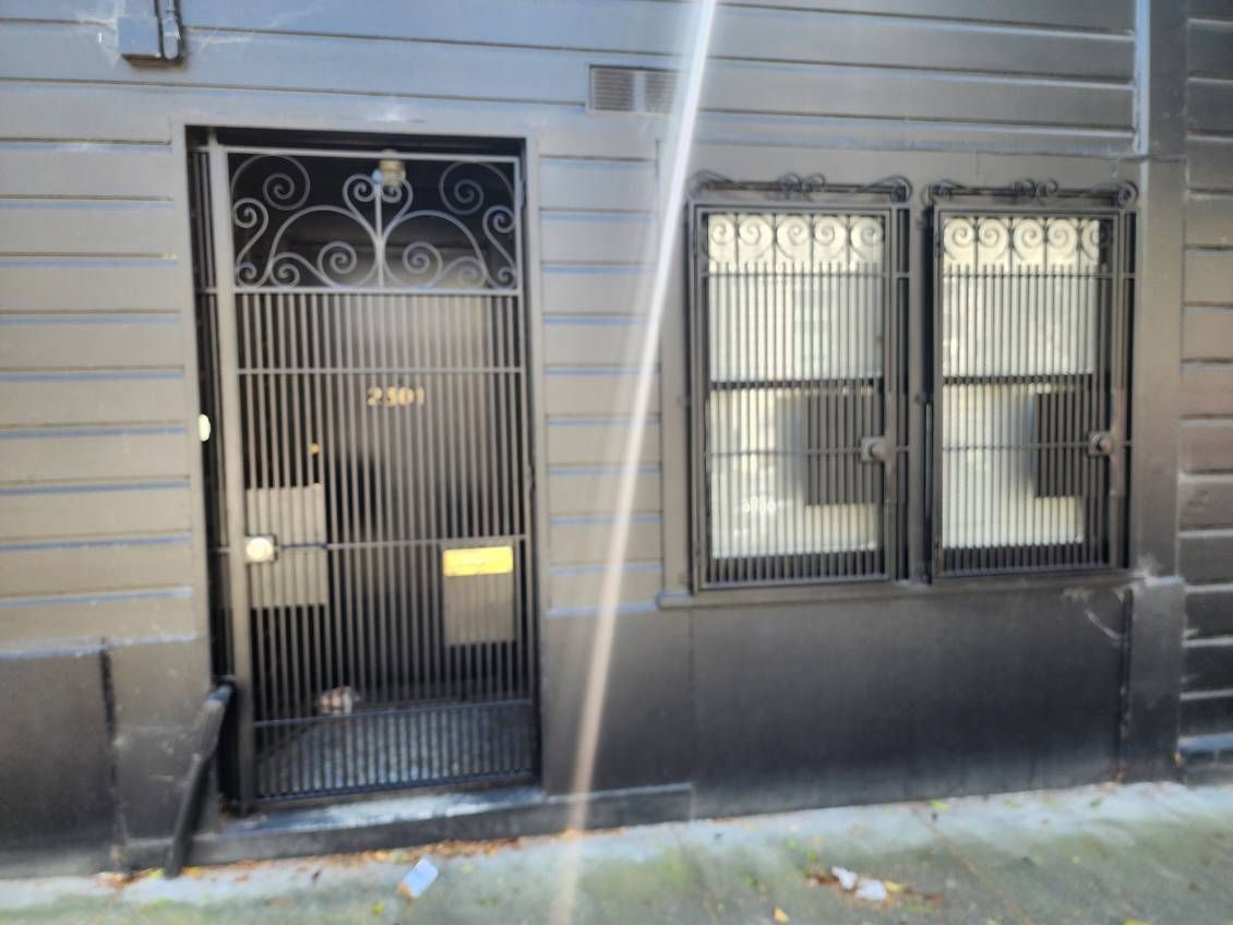 A black building with a wrought iron gate and two windows