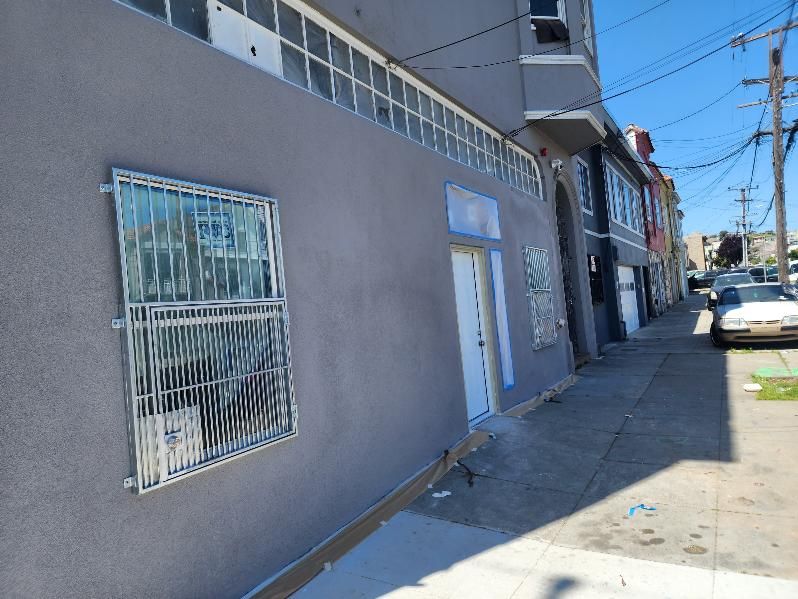 A building with a lot of windows and a car parked in front of it.