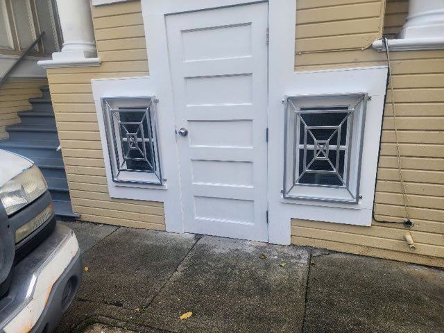 A white truck is parked in front of a yellow house