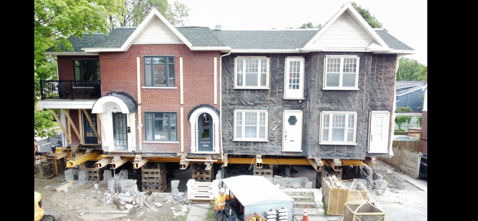 Maisons à deux étages surélevées sur parpaings lors de leur construction. Façades en briques et en bois.