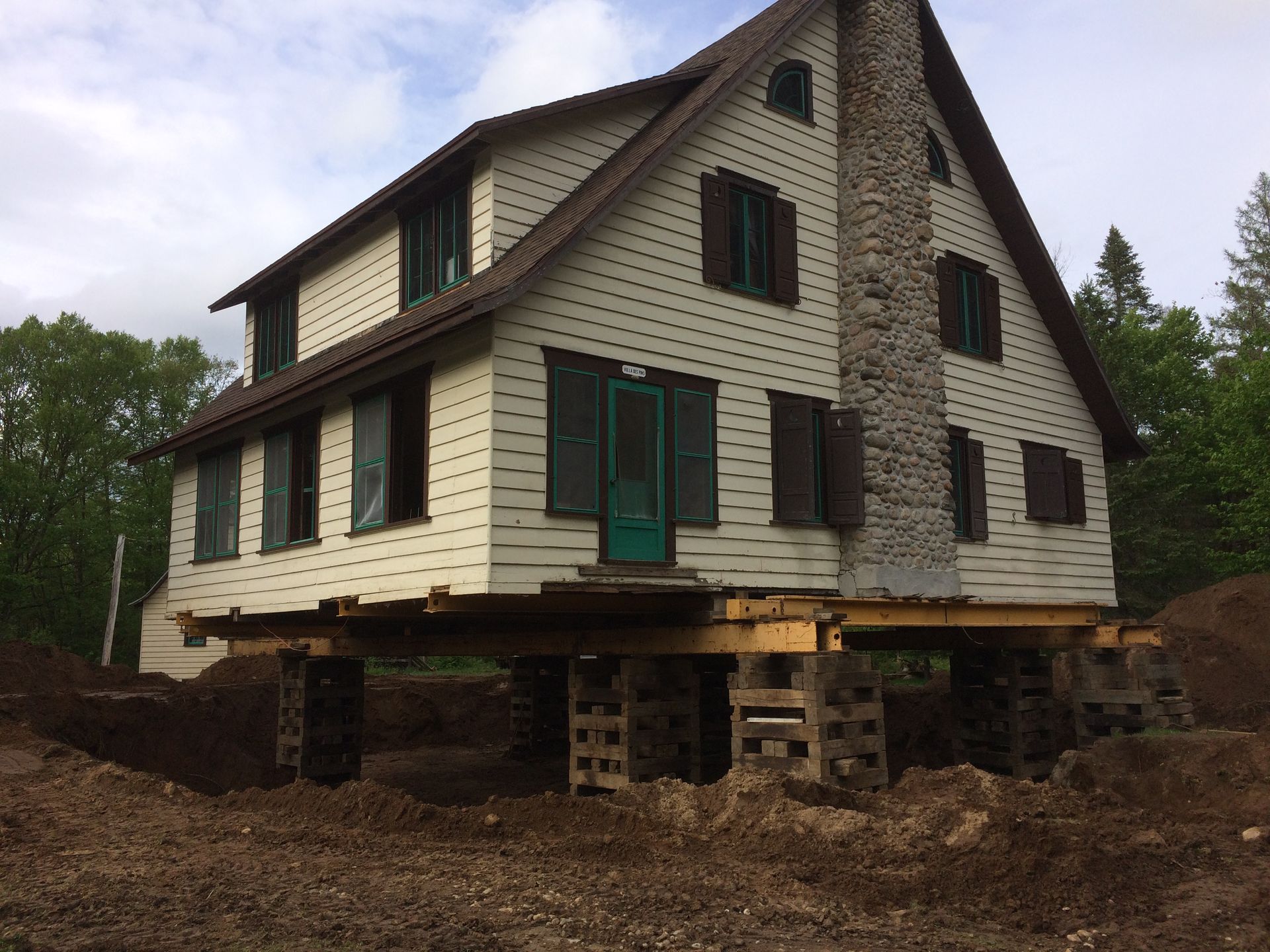 Maison surélevée sur blocs de béton, probablement pour des travaux de réparation des fondations.