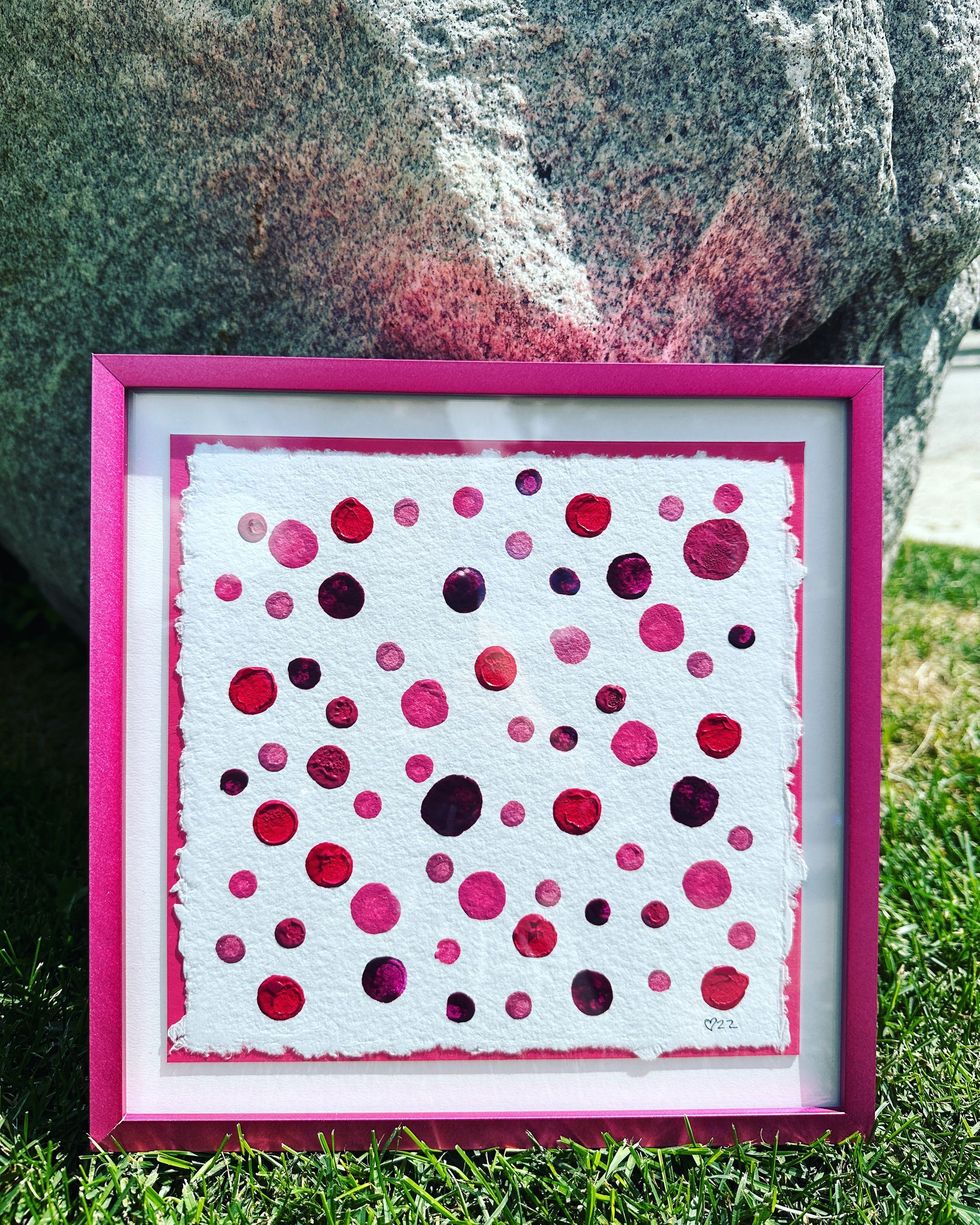 A picture in a pink frame with red polka dots on it