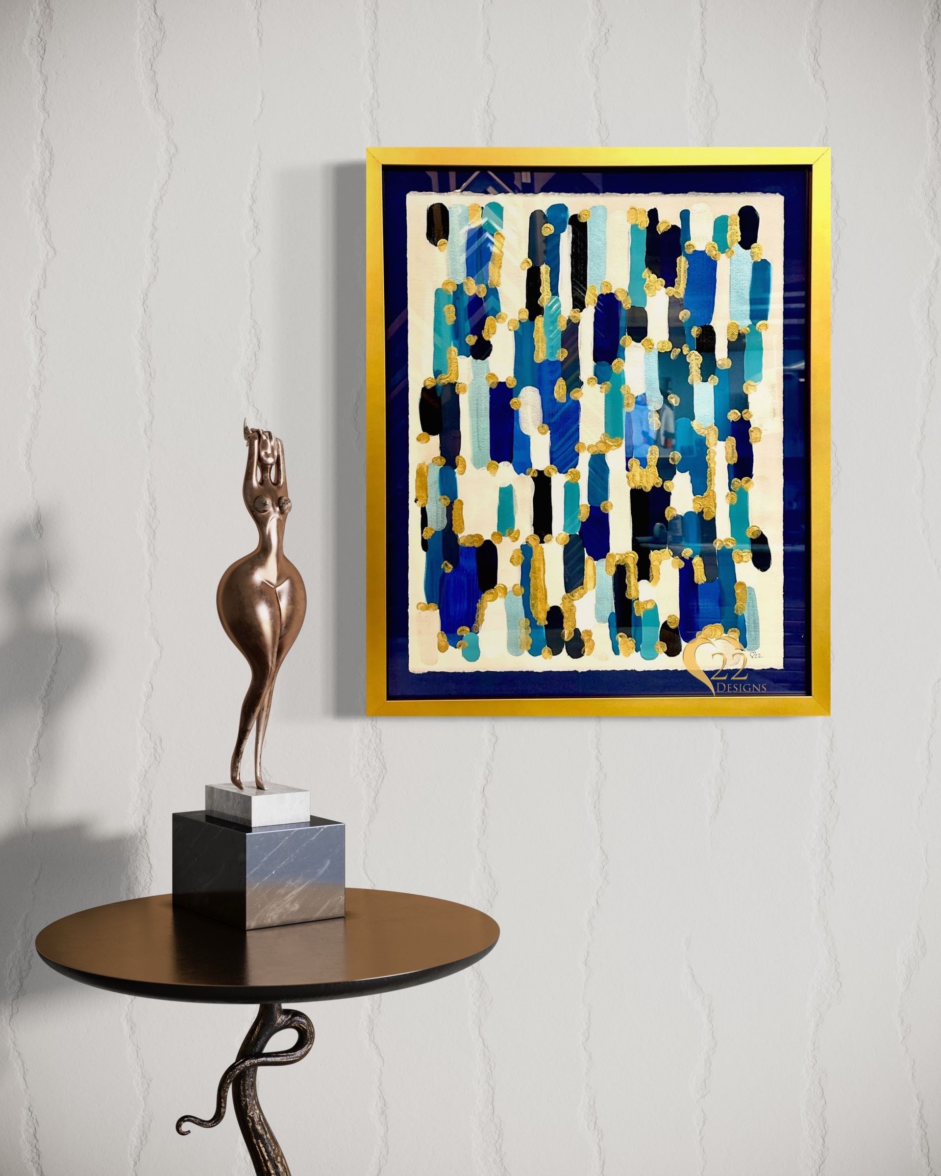 A painting is hanging on a wall next to a statue on a table.