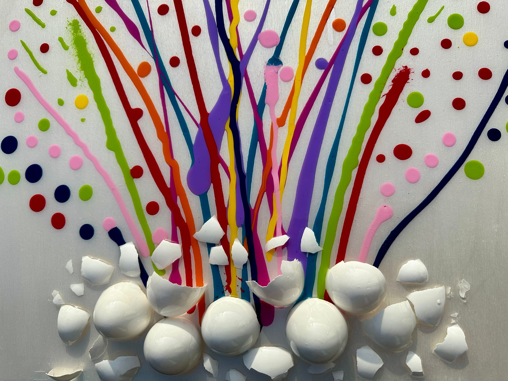 A bunch of eggs are laying on a table with a colorful background