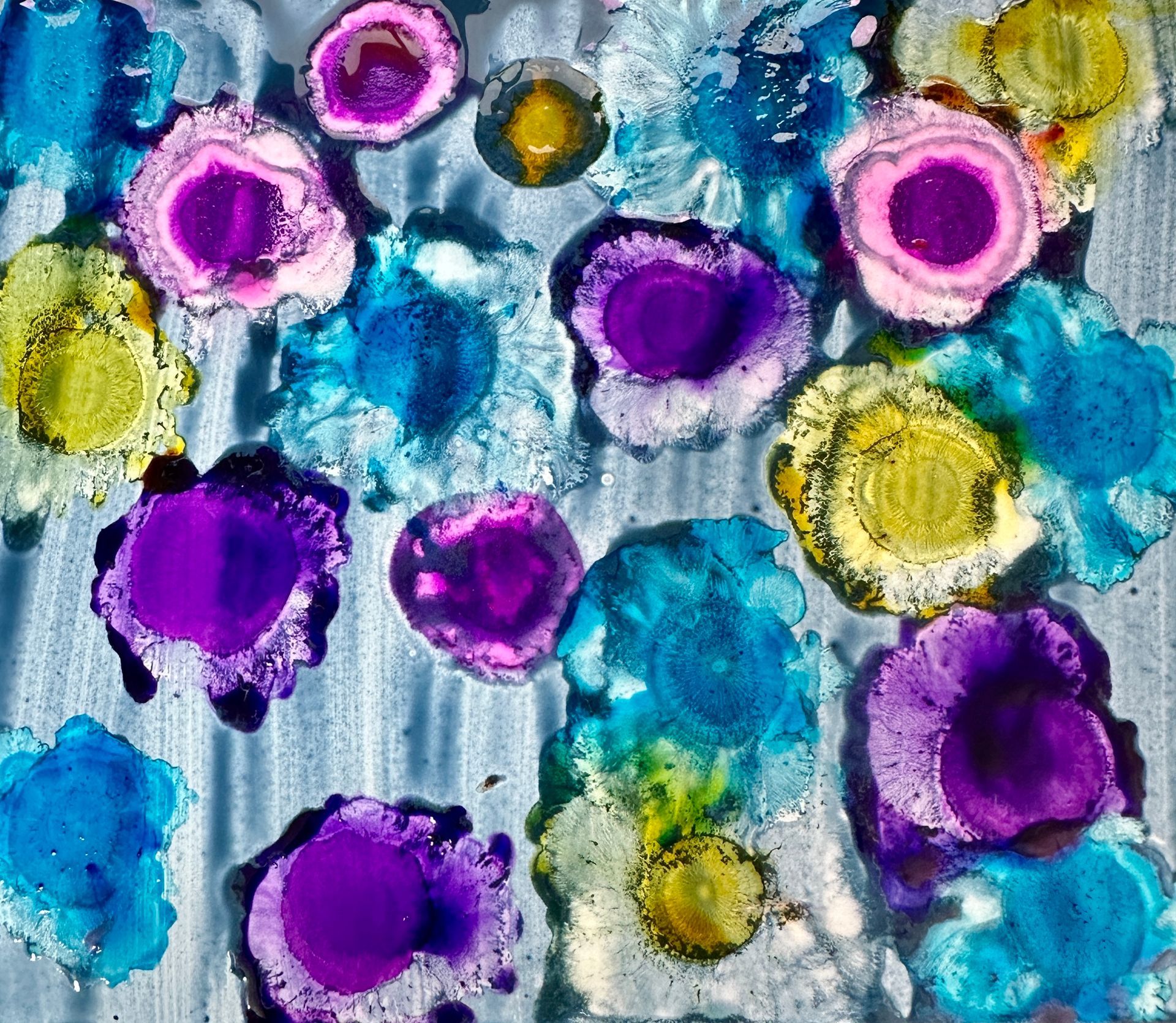 A painting of purple and blue circles on a gray background