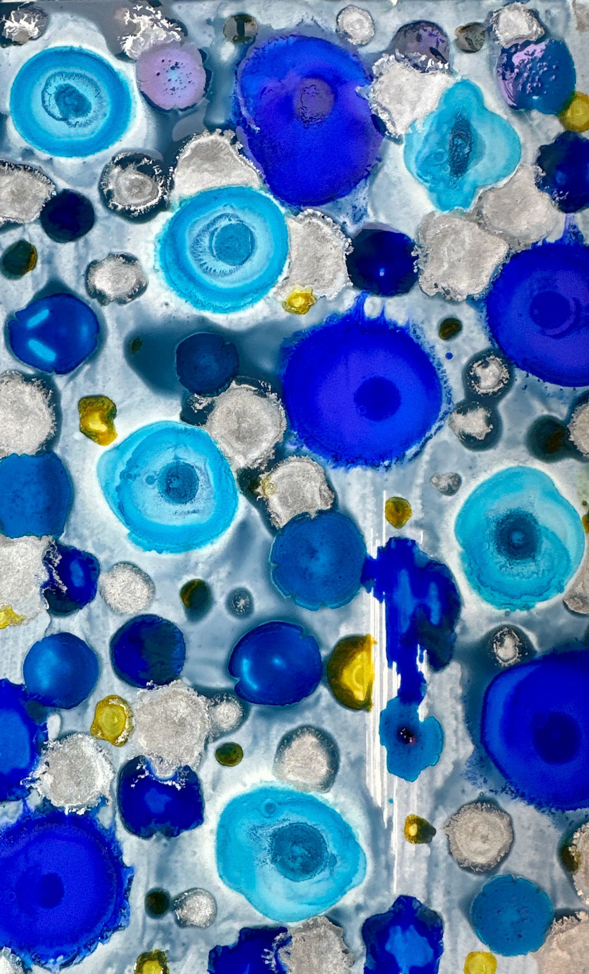 A close up of a painting of blue circles on a white background.