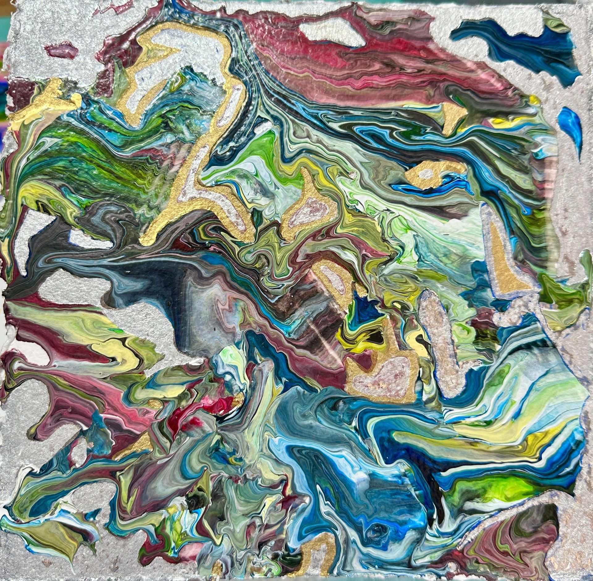 A close up of a colorful painting on a concrete surface.