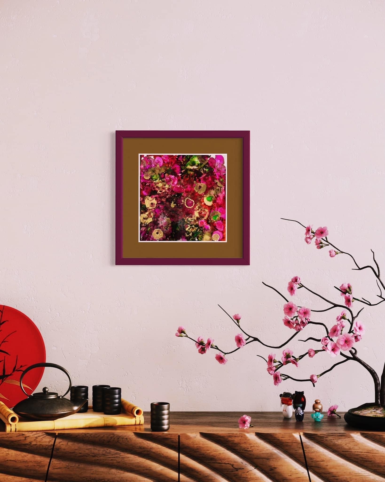 A picture of flowers is hanging on a wall above a table.