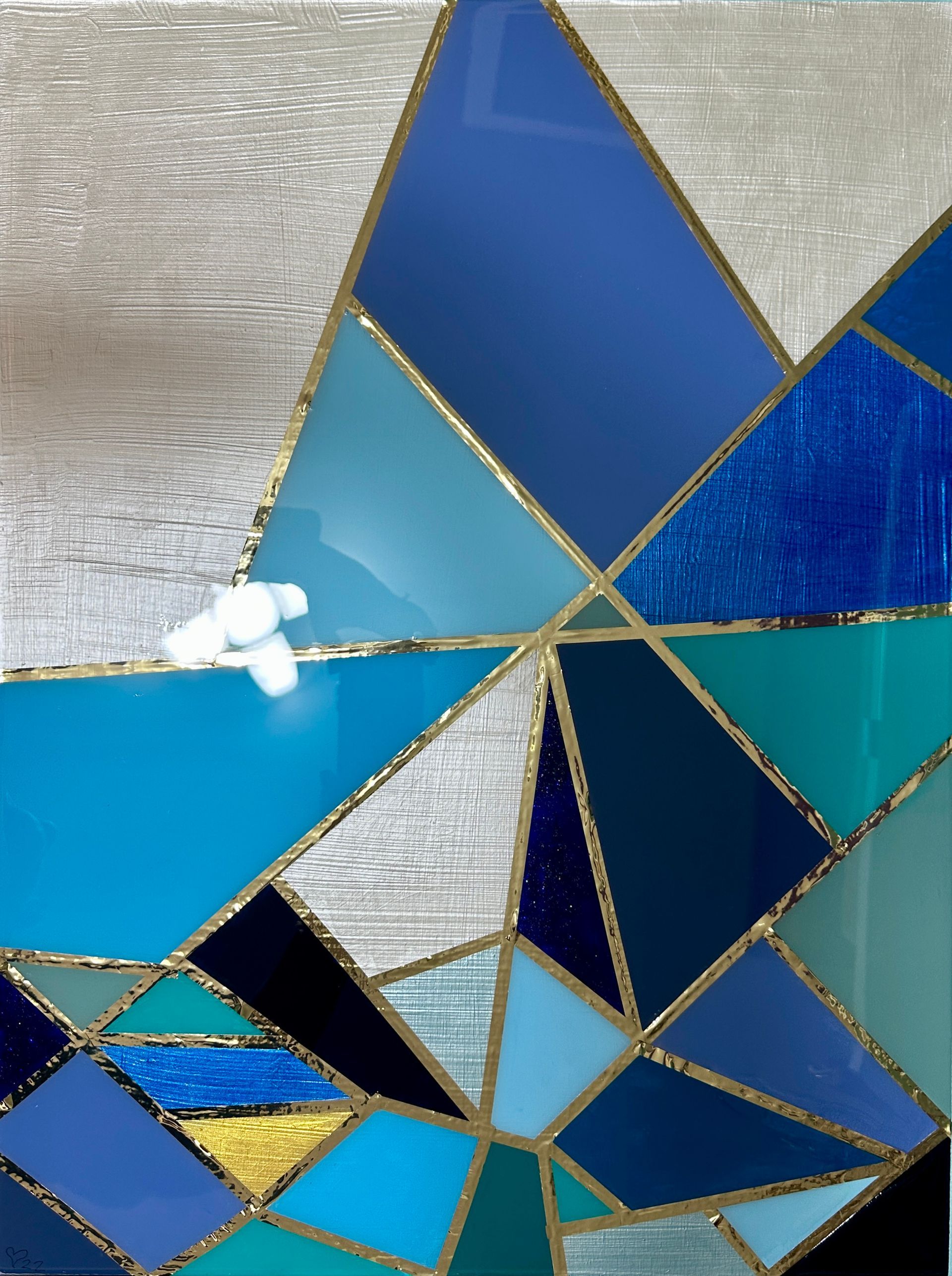 A stained glass window with blue triangles and gold trim