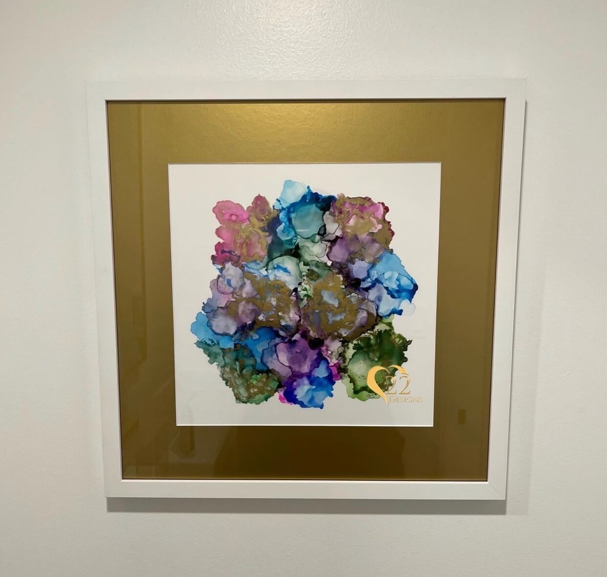 A painting of flowers in a gold frame on a white wall