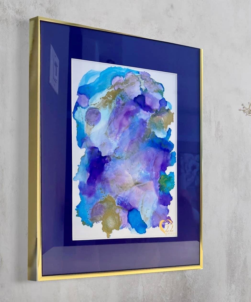 A painting in a blue frame is hanging on a wall