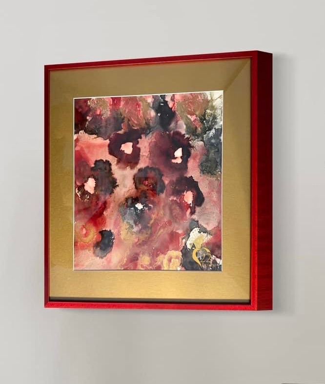 A framed painting of flowers in a red frame