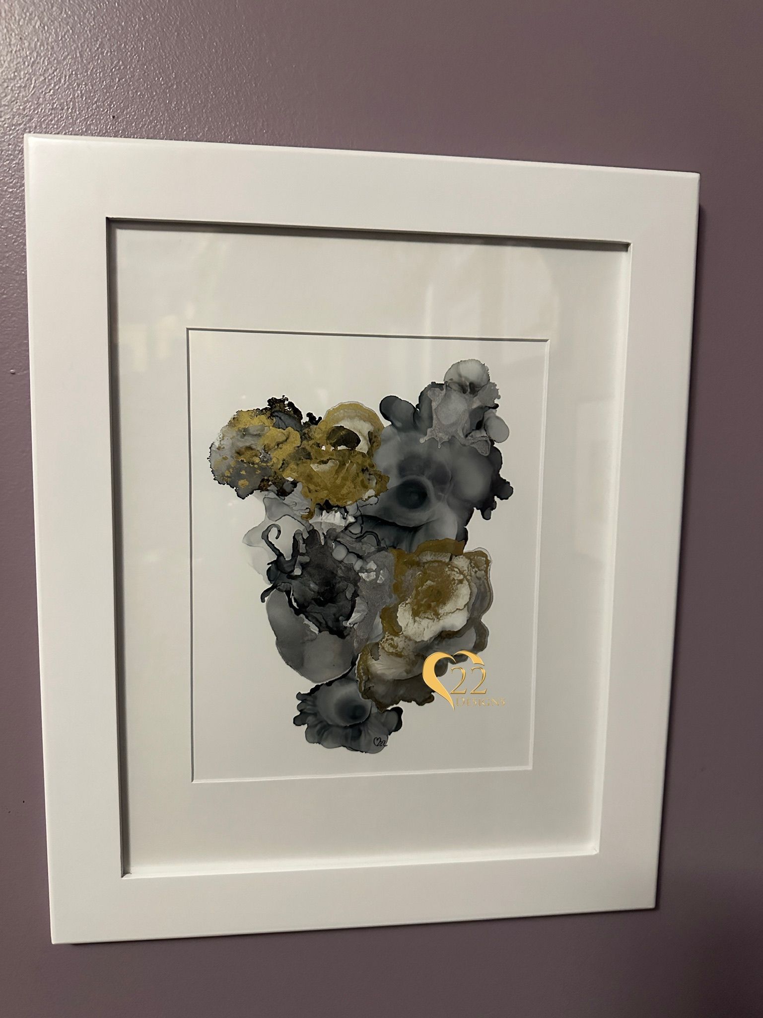 A framed painting is hanging on a purple wall.