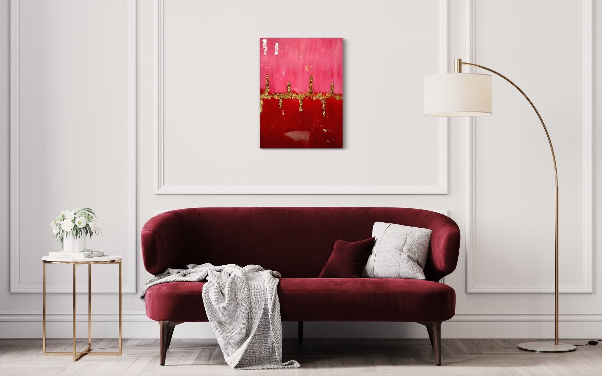 A living room with a red couch and a painting on the wall.