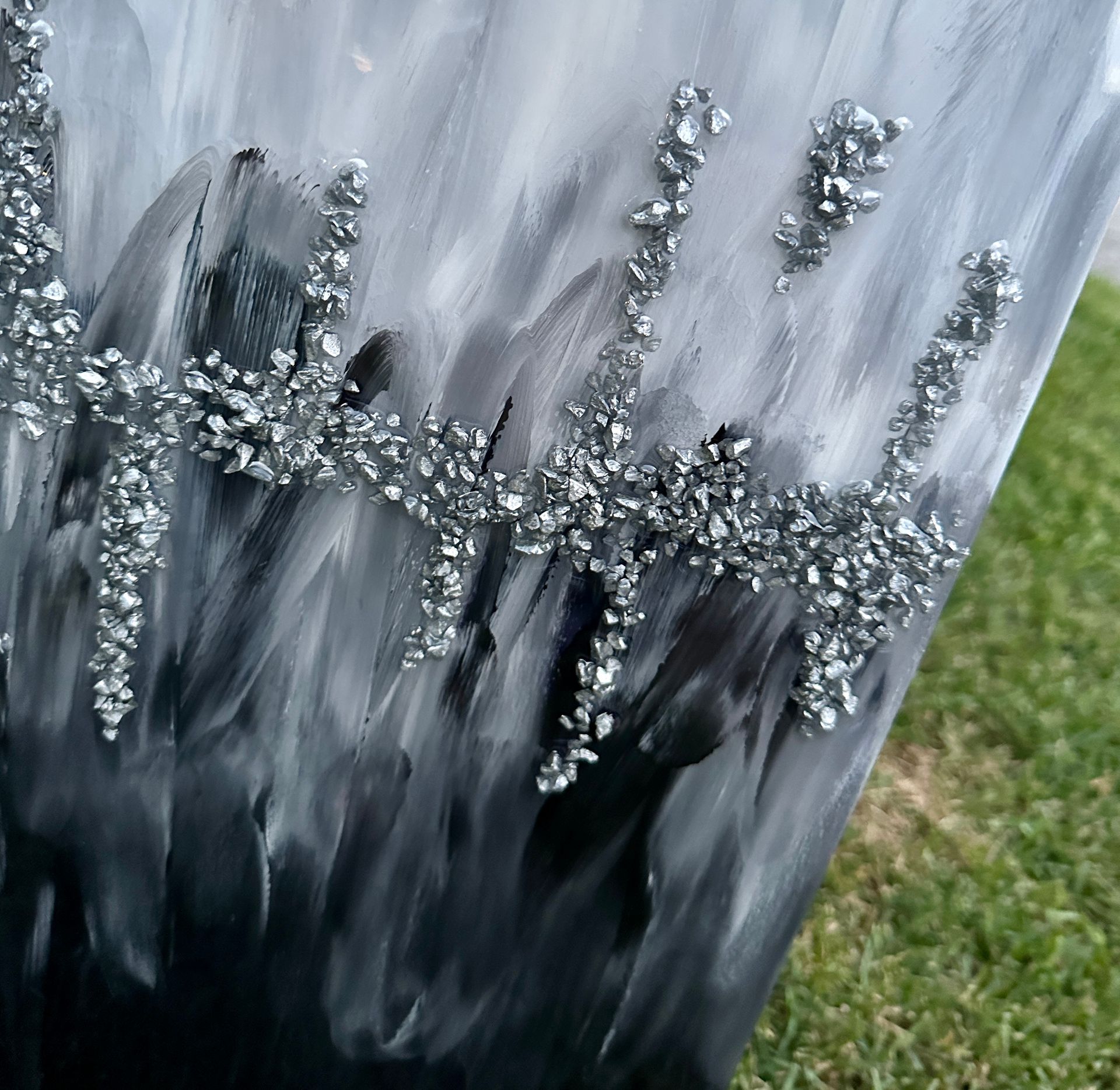 A black and white painting with silver rhinestones on it