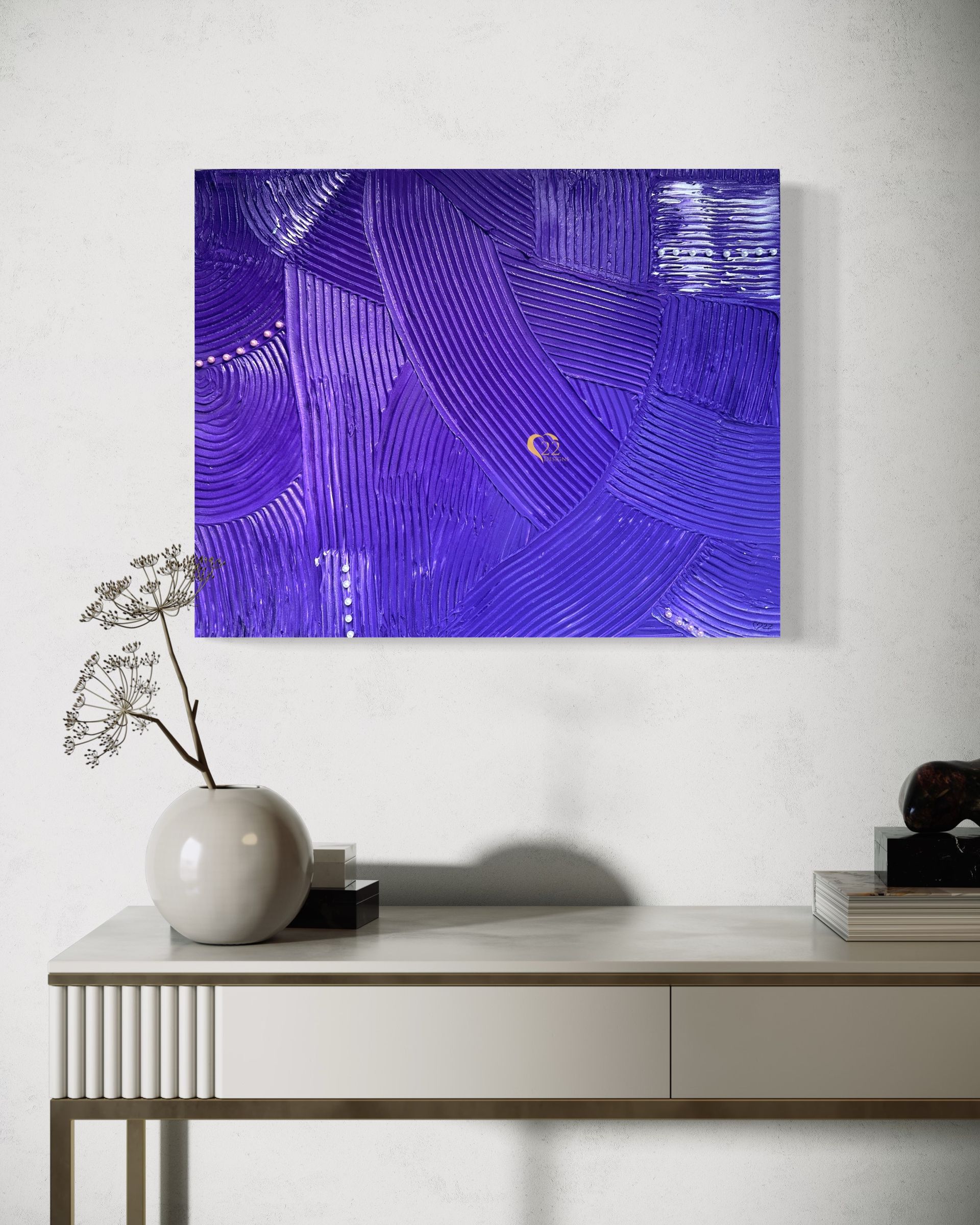 A purple painting is hanging on a white wall above a white table.