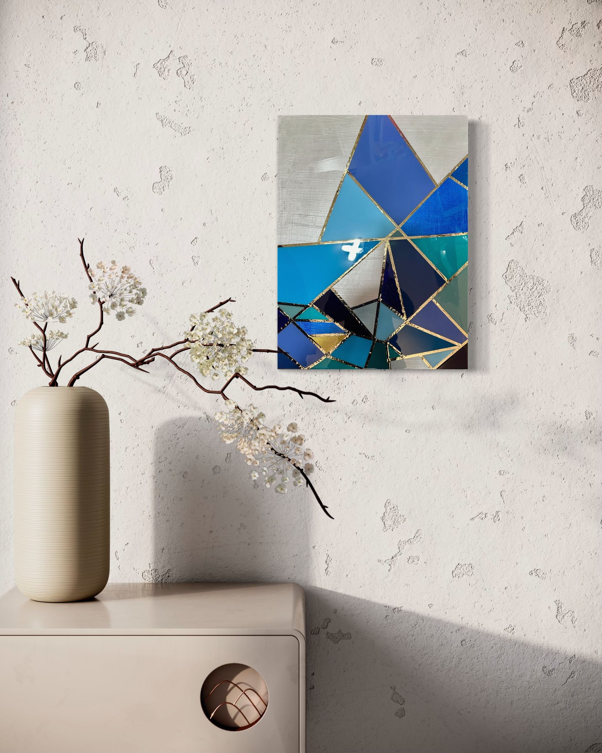 A painting is hanging on a wall next to a vase of flowers.