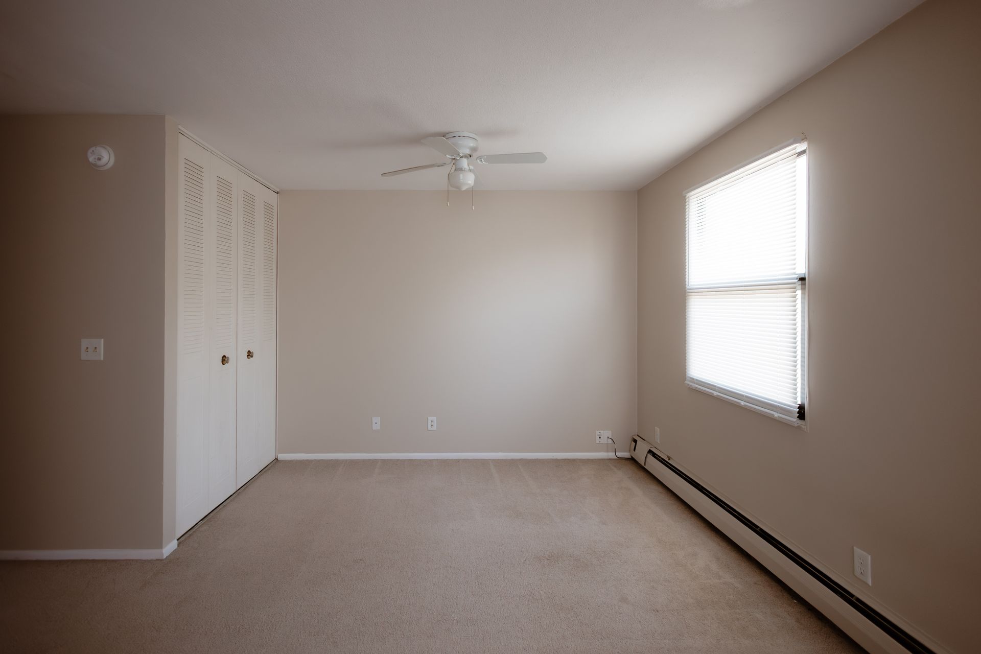 Room with ceiling fan, beige closet, large window, and carpet. Apartment in South Minneapolis by RightMove Properties.