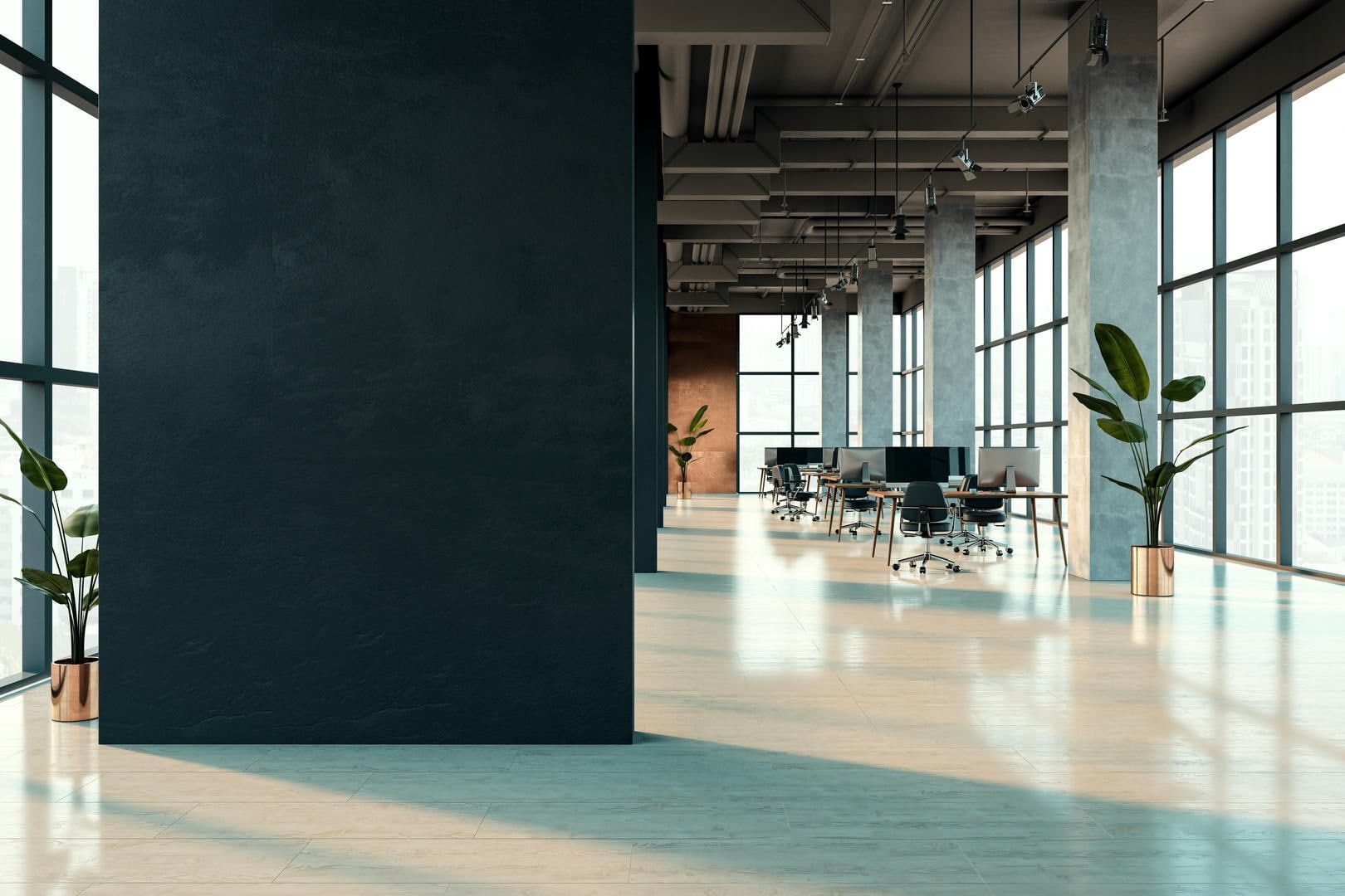 A large empty office with a black wall and lots of windows.