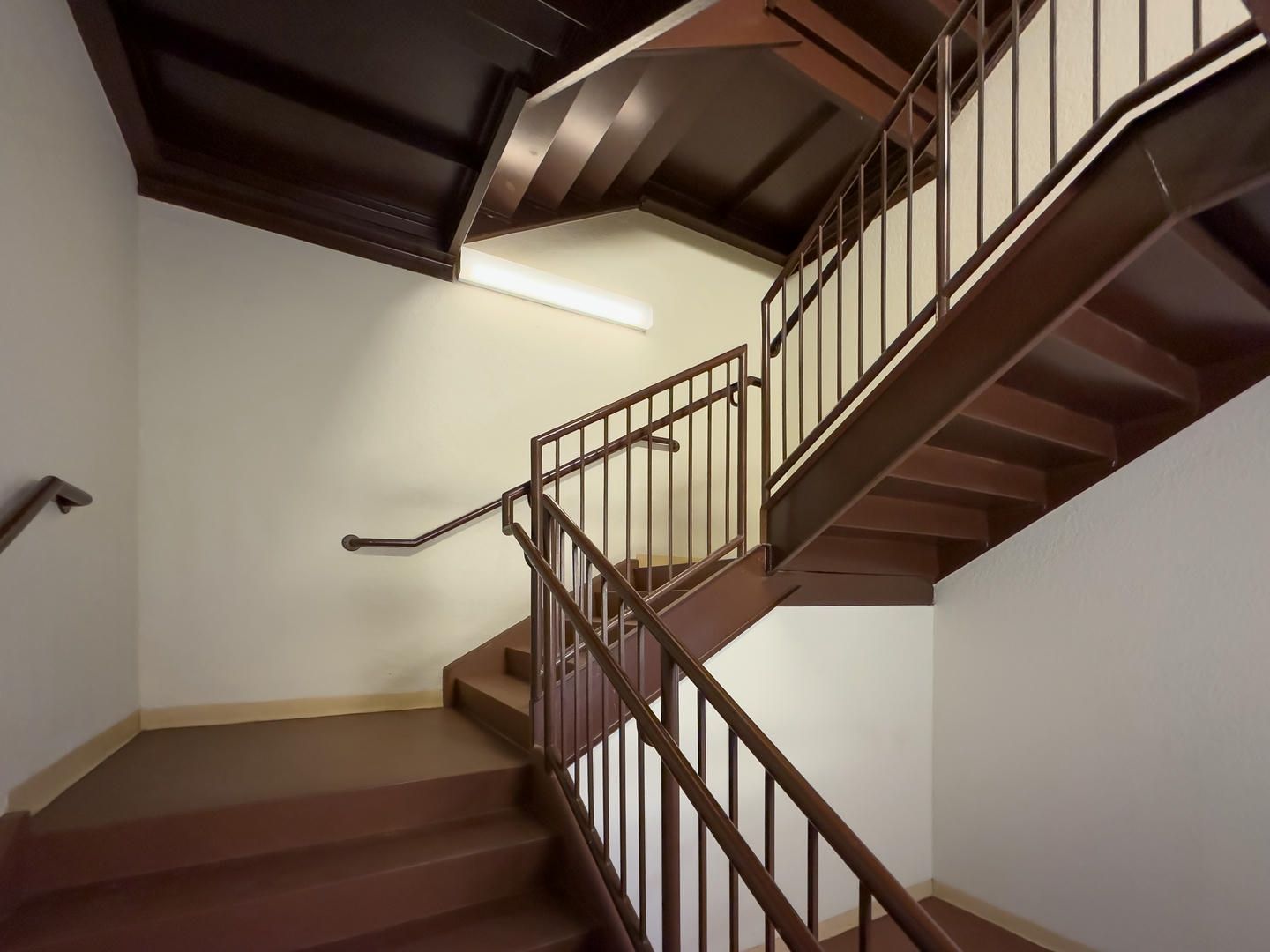 A staircase in a building with a metal railing