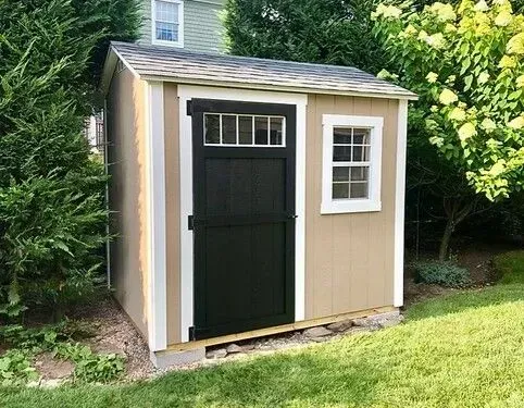 A small shed with a black door and windows.