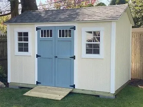 A white shed with blue doors and windows.