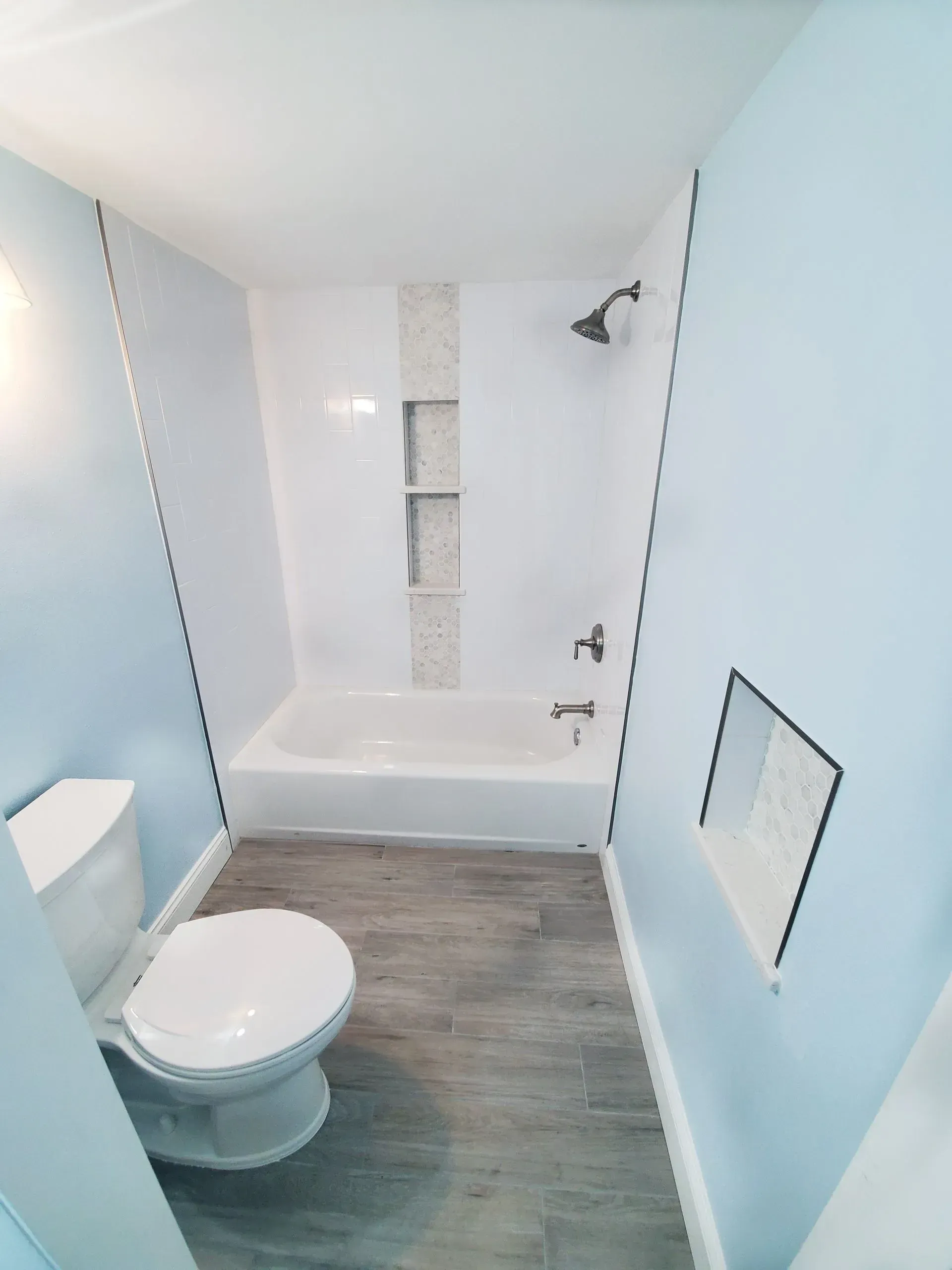 A bathroom with a toilet a tub and a shower