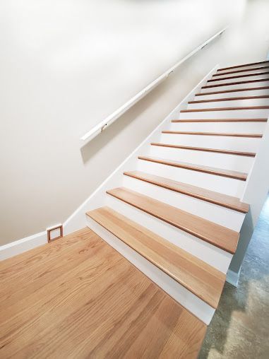 A set of stairs with wooden steps and a white railing.