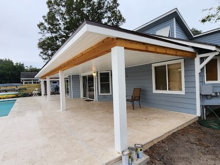 A house with a covered patio and a pool in the backyard.