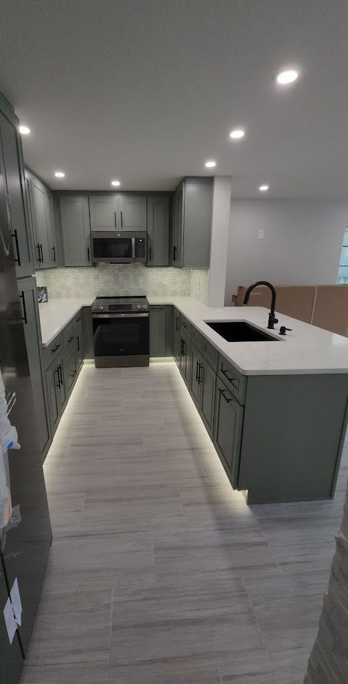 A kitchen with a stove , sink , and microwave.