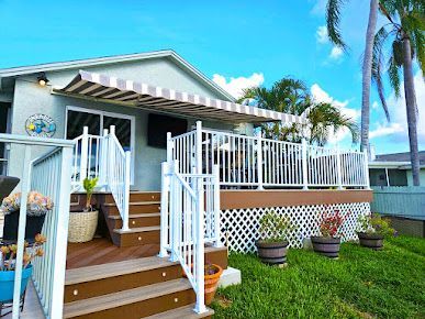 A mobile home with a large deck and stairs.