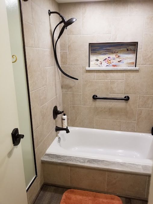 A bathroom with a bathtub and a shower.