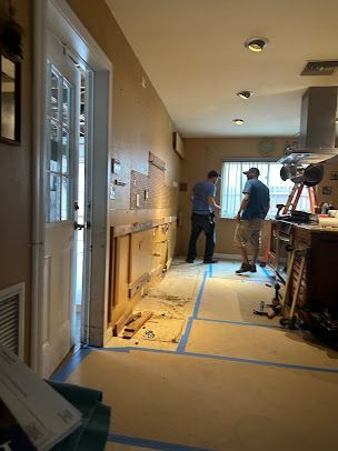 A group of men are working on a kitchen remodel.