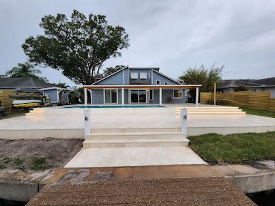 A house with a swimming pool and a dock in front of it.