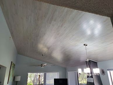 A living room with a vaulted ceiling and a ceiling fan.