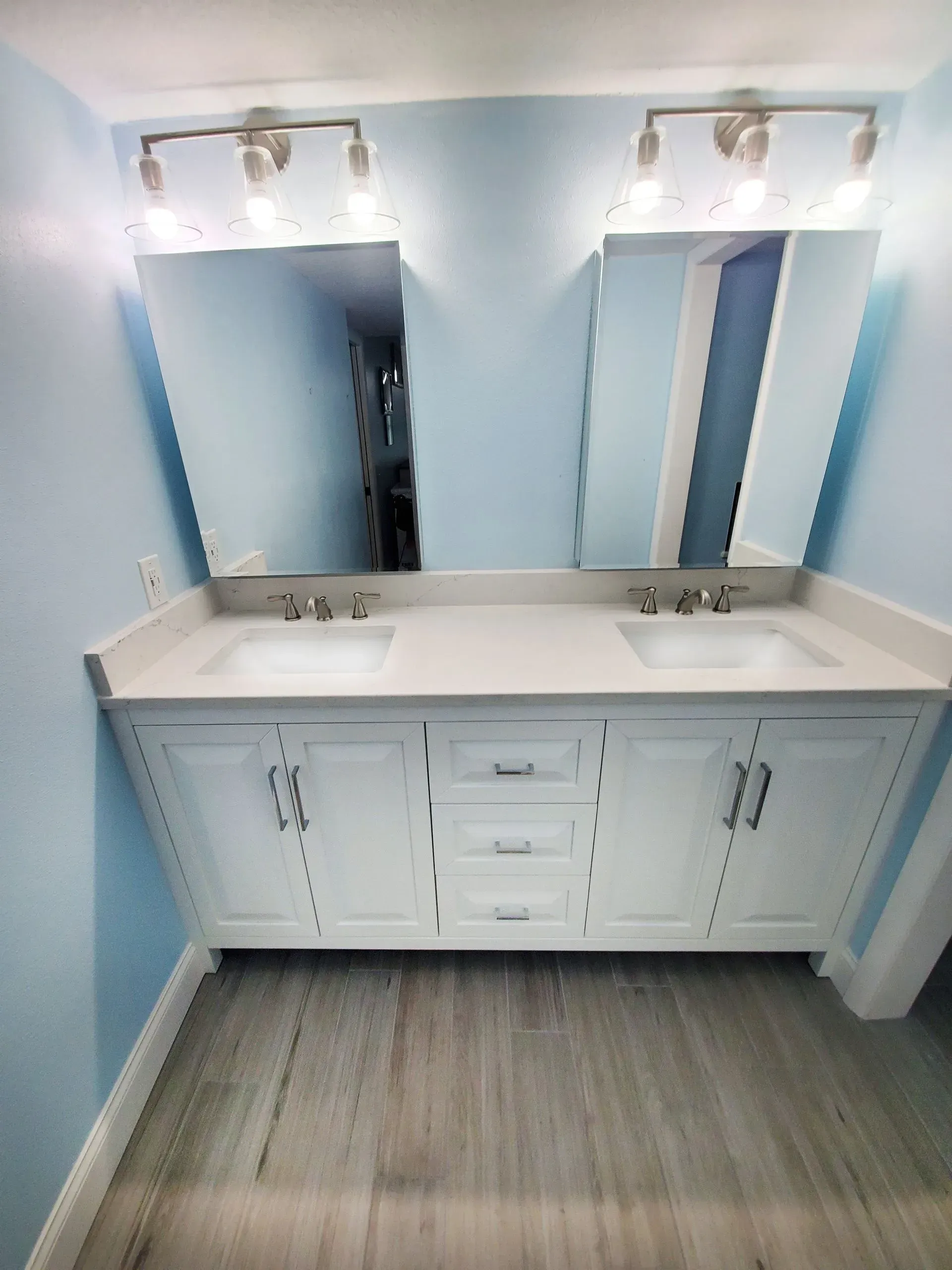A bathroom with two sinks and two mirrors.