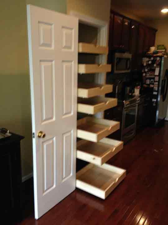 White pantry door with pull-out drawers in a kitchen setting.