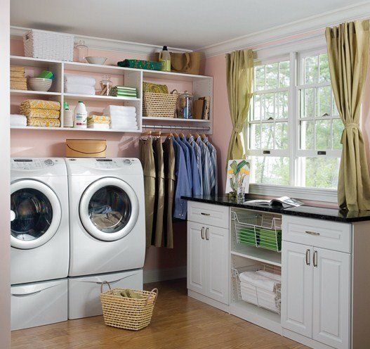 Laundry room with washer/dryer, storage shelves, clothing rack, and window with curtains.