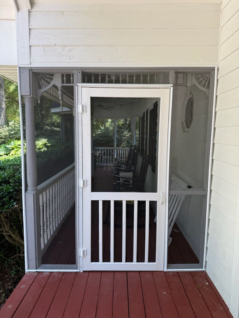 White screen door with bars, on a porch with red floor and gray screens.