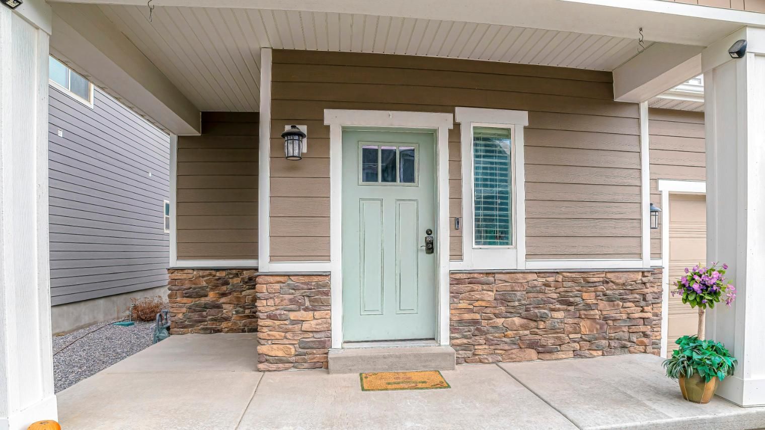 The front door of a house with a porch and a blue door.
